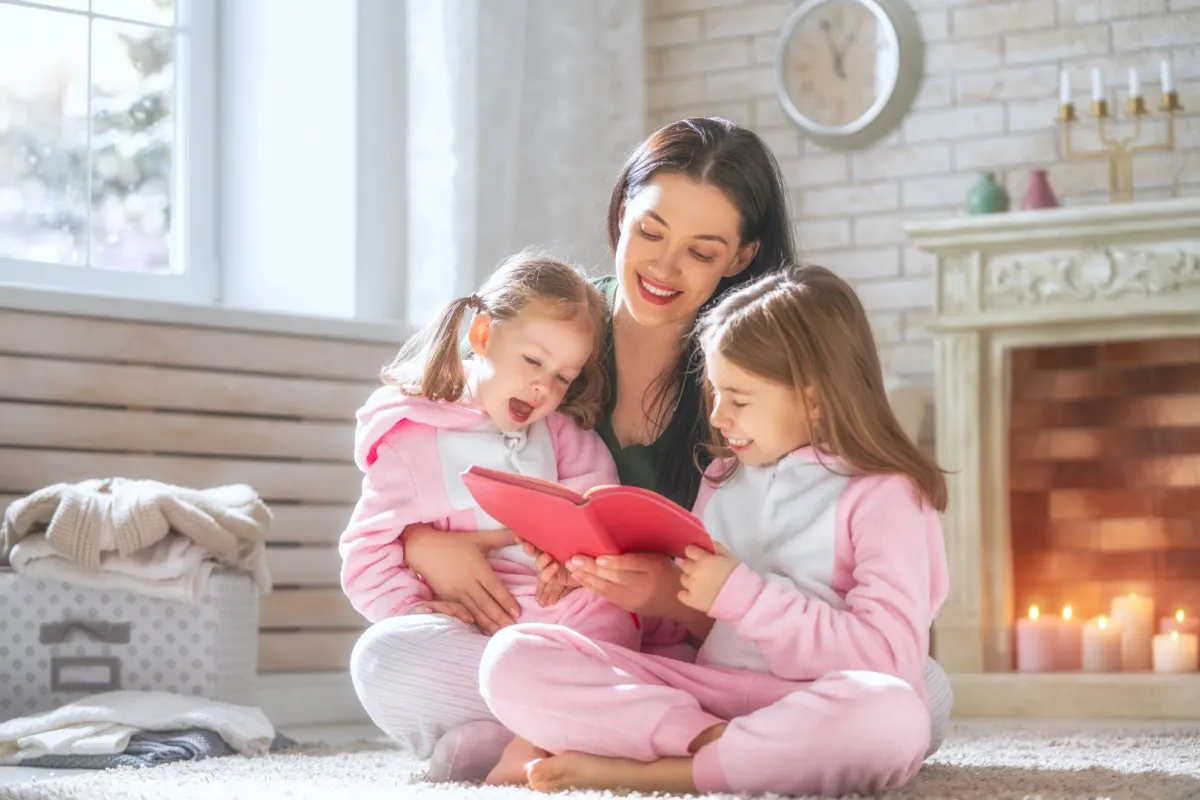 صورة أم تقرأ القصص لطفلتيها