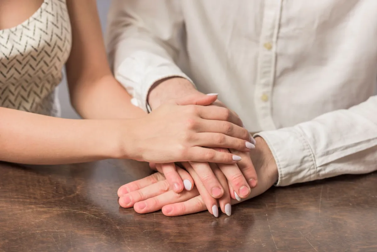 زوجة تضع يدها على يد زوجها بمحبة