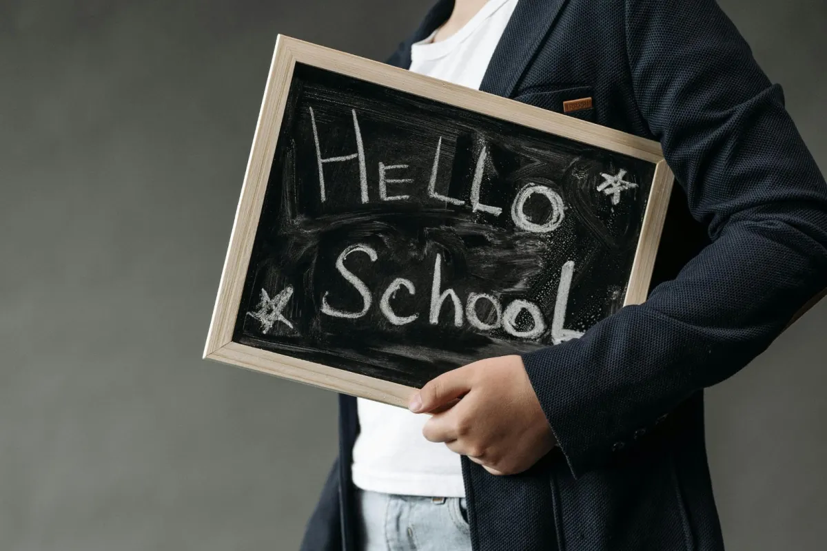 شاب يحمل لافتة اهلا بالمدرسة