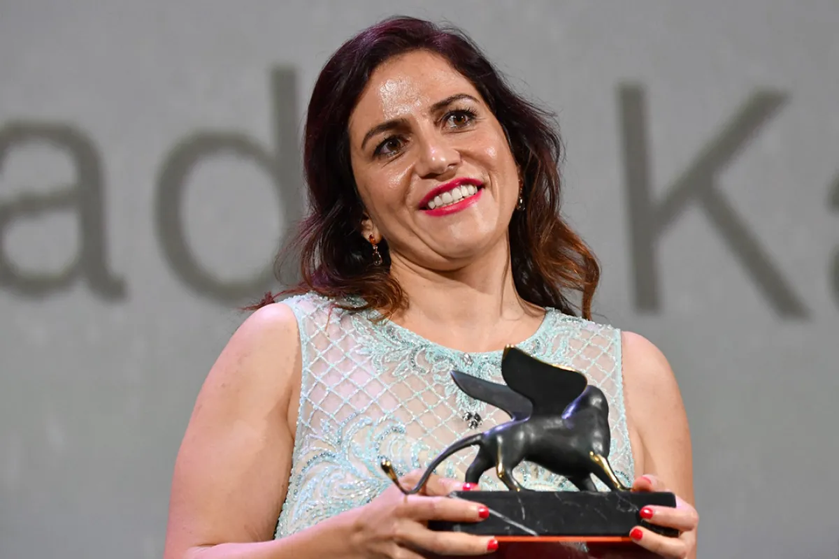 المخرجة سؤدد كعدان بعد حصولها على جائزة ‏Lion of the Future‏ في فينسيا- ‏Director Soudade Kaadan poses ‎after she received the Lion of the Future "Luigi De Laurentiis" Venice Award‏ - مصدر الصورة: ‏‏(‏Photo by Alberto PIZZOLI / AFP‏)‏