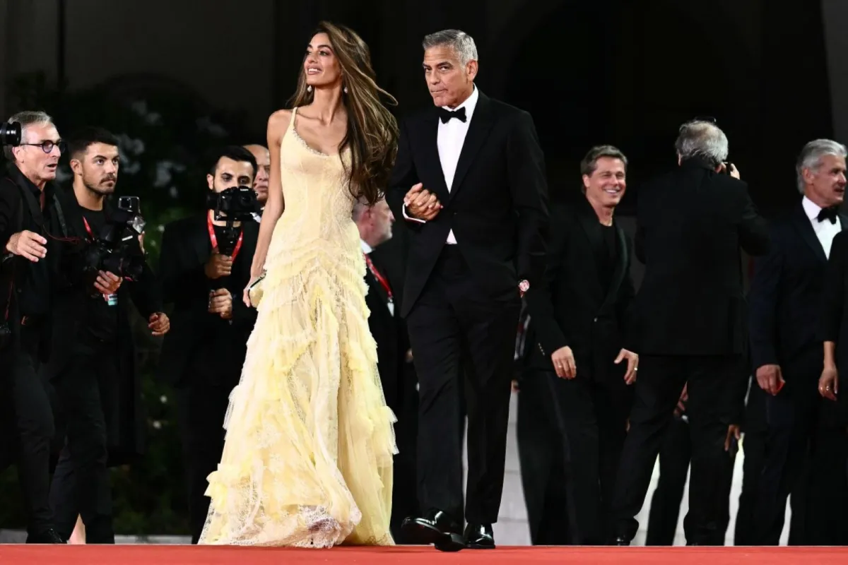 جورج كلوني وزوجته أمل يحضران السجادة الحمراء لفيلم "Wolfs" خلال مهرجان فينيسيا السينمائي الدولي الحادي والثمانين في فينيسيا ليدو (George Clooney and his wife Amal attend the red carpet of the movie "Wolfs" during the 81st International Venice Film Festival at Venice Lido). مصدر الصورة: Marco BERTORELLO / AFP