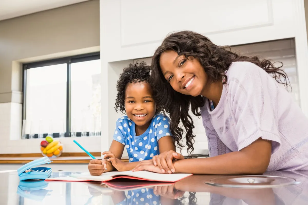 صورة أم تقوم بتعليم طفلتها