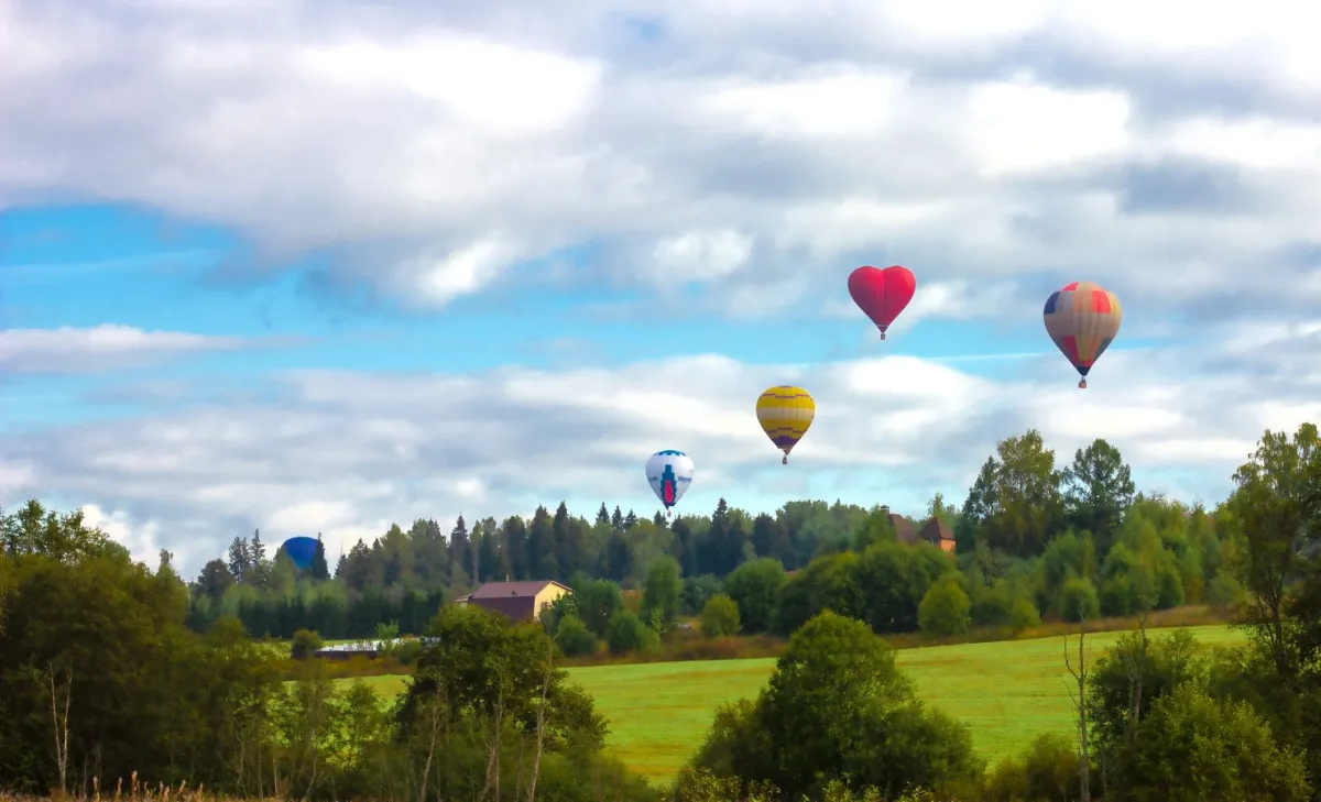 بالونات الهواء الساخن في السماء الزرقاء مع السحب