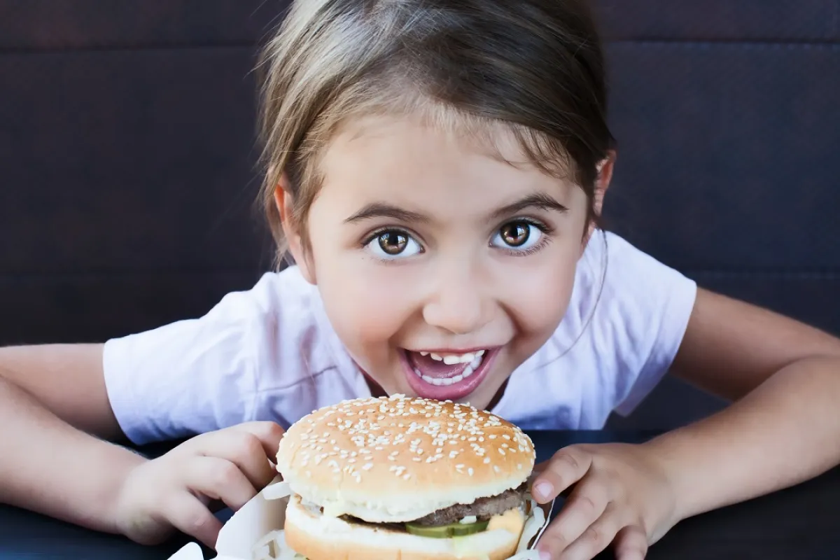 صورة لطفلة تتناول ساندوتش