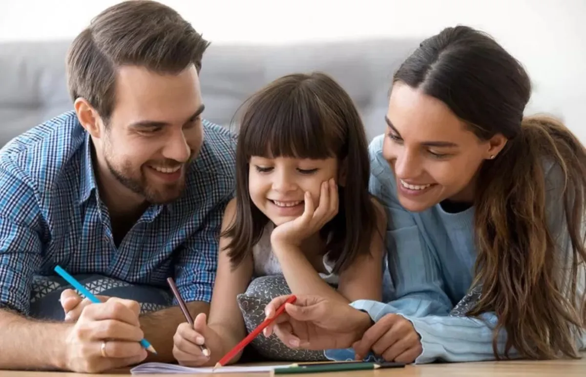 فتاة صغيرة تحاول تعلُّم الرسم مع والديها