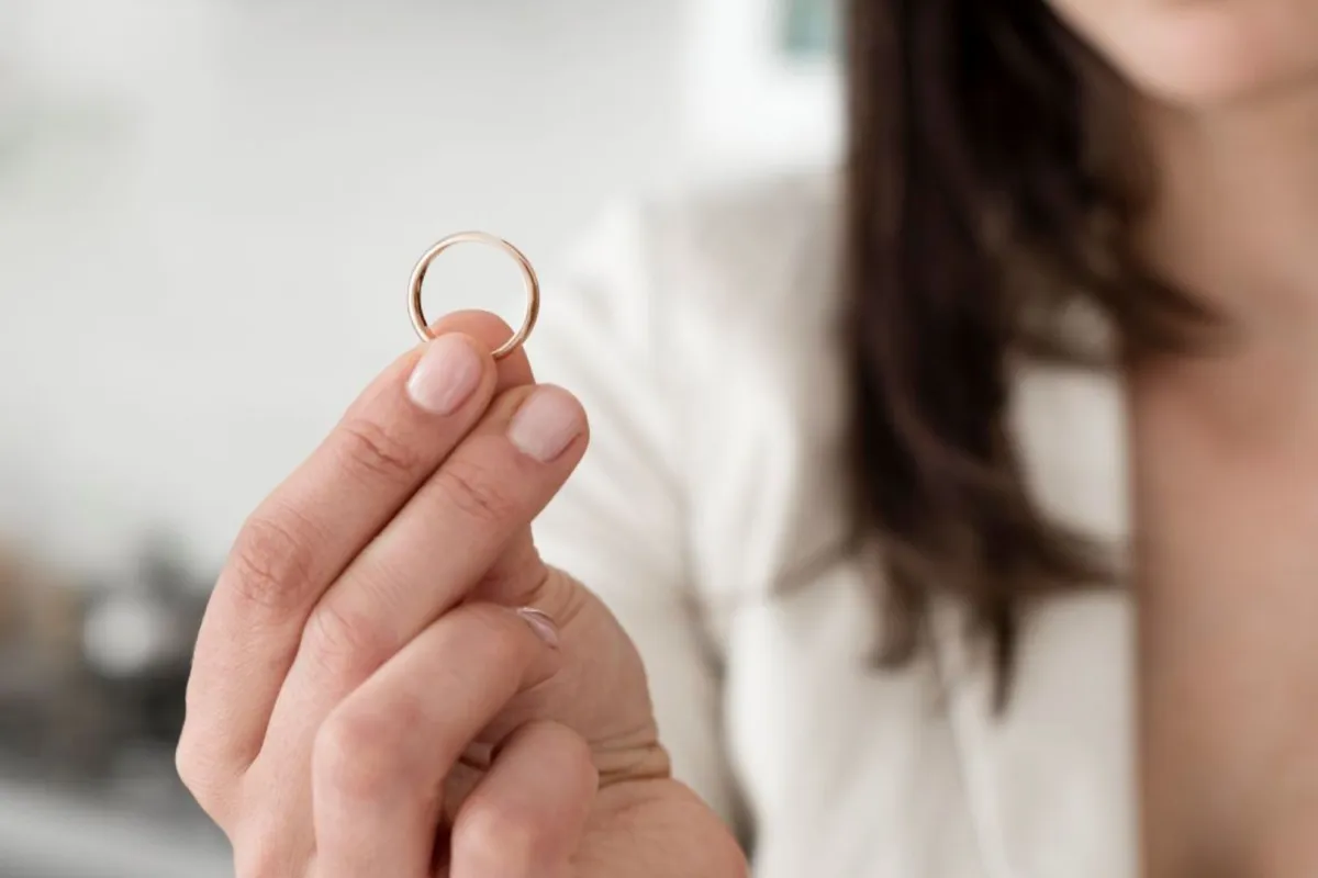 عروس شابة تمسك دبلة خطوبتنها بحزن وندم