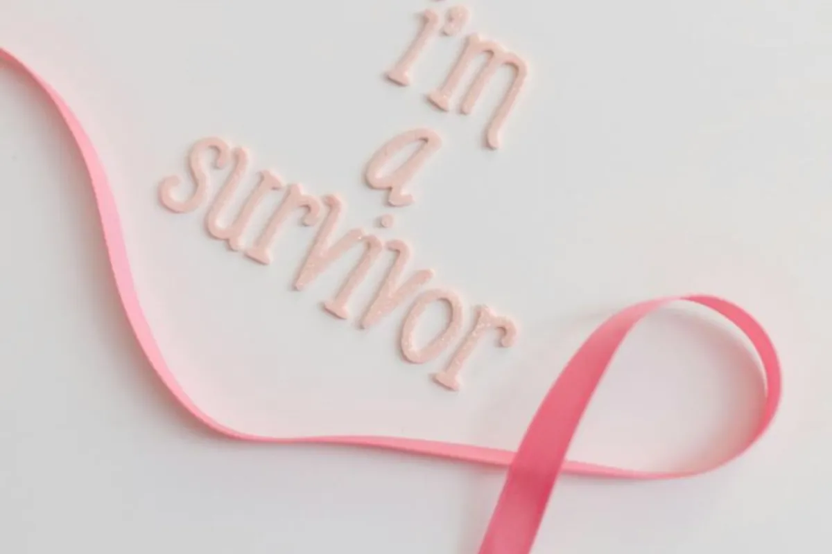 كارت يحمل عبارة أنا ناجية وبه شارة محاربات سرطان الثدي