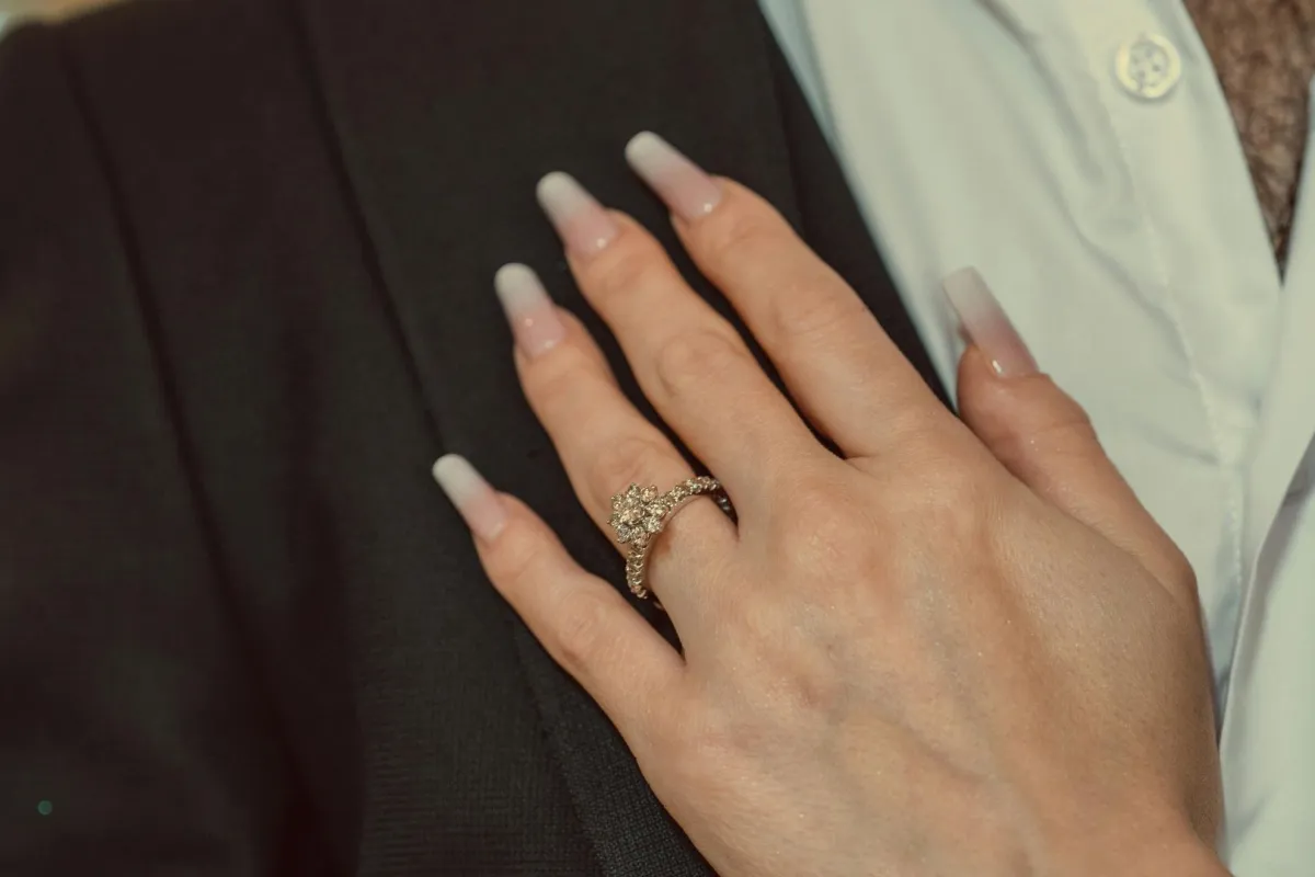 خطيبة تضع يدها وبإصبعها خاتم الخطوبة على صدر خطيبها