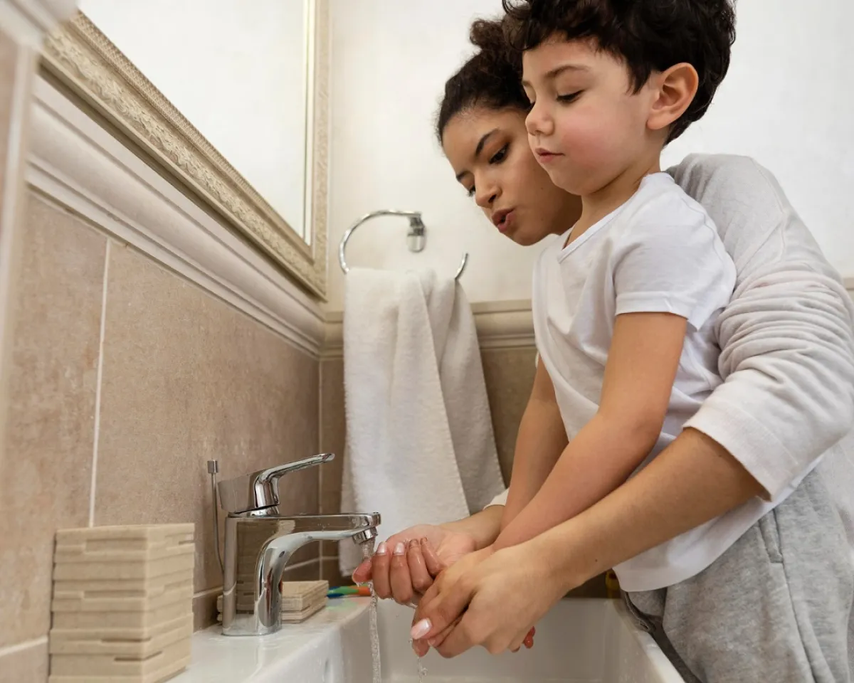صورة لأم تعلم طفلها غسل اليدين