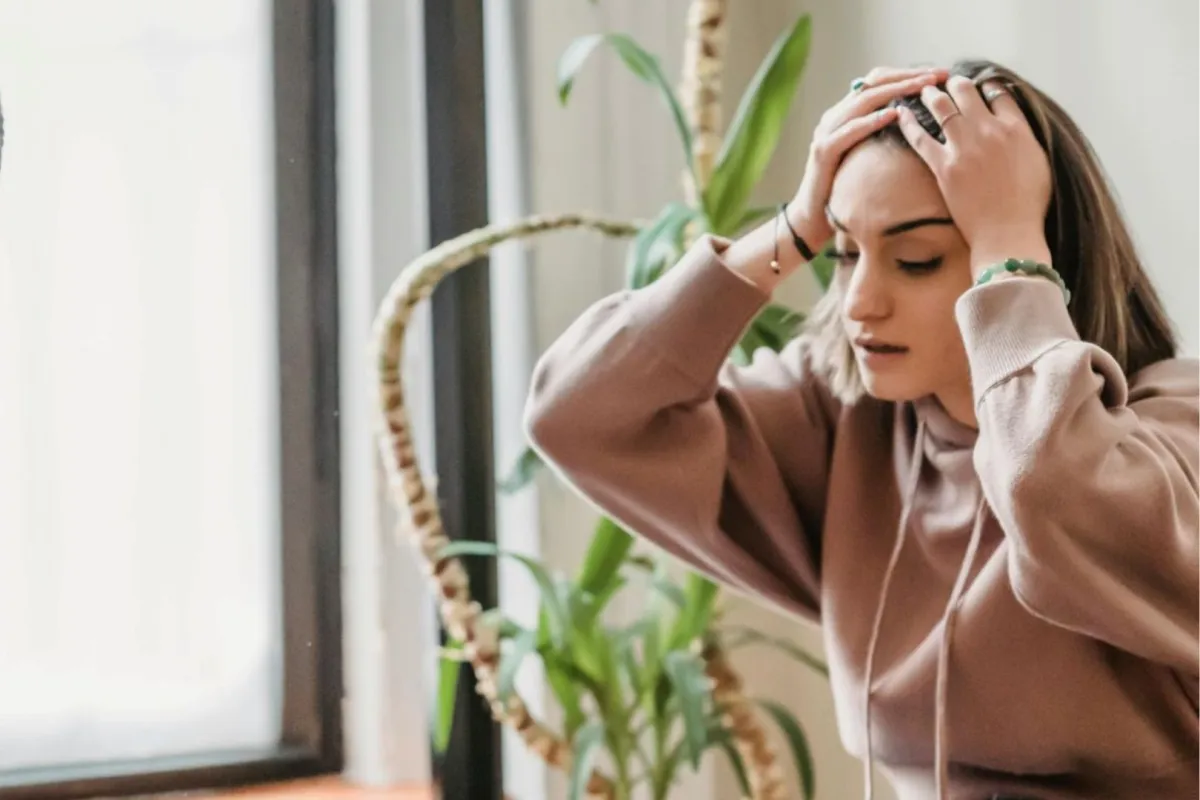 شابة تواجه الانتقادات بضيق وترفع يديها فوق رأسها  