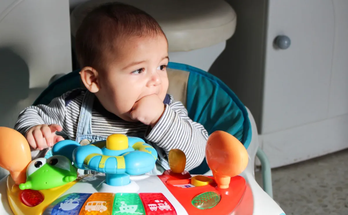 صورة لرضيع يضع أصابعه في فمه بسبب آلام التسنين