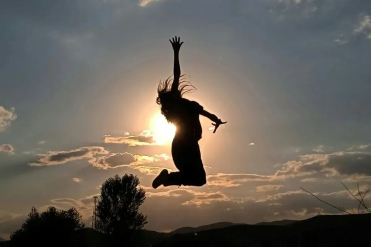 فتاة سعيدة تقفز لأعلى من فرط فرحتها بالحياة