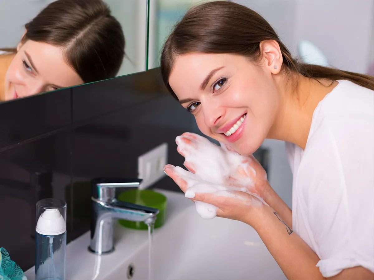 فتاة تغسل بشرتها بغسول طبيعي