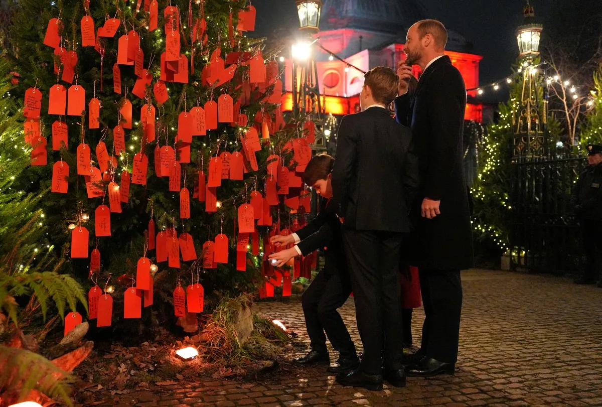 الأمير لويس أثناء وضع رسالته على شجرة الكريسماس (  Prince Louis placing his message on the Christmas tree). مصدر الصورة:  Jordan Pettitt / POOL / AFP