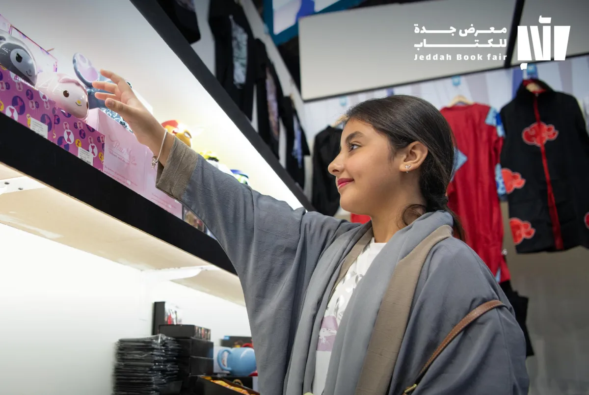 زائرة تستمع بالأجواء الثقافية والترفيهية في منطقة المانجا - الصورة من حساب معارض الكتاب في السعودية على إكس