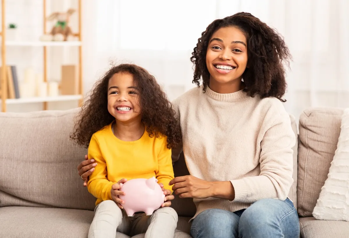 صورة لأم وطفلتها وحصالة الادخار