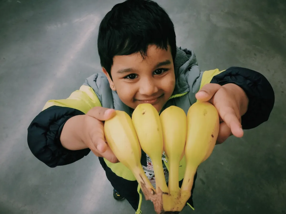 صورة طفل يقدم الموز