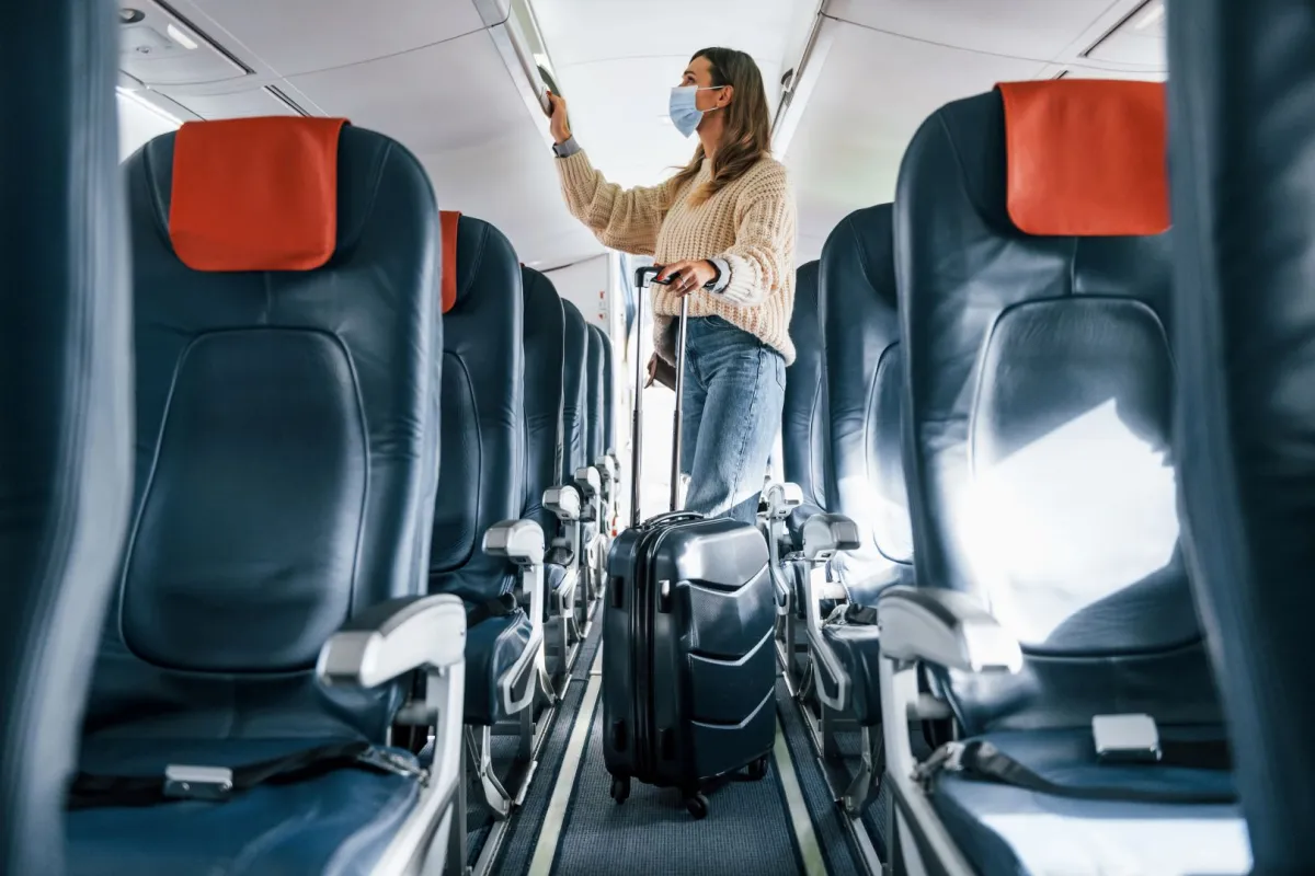 مسافرة ترتدي قناعاً واقياً