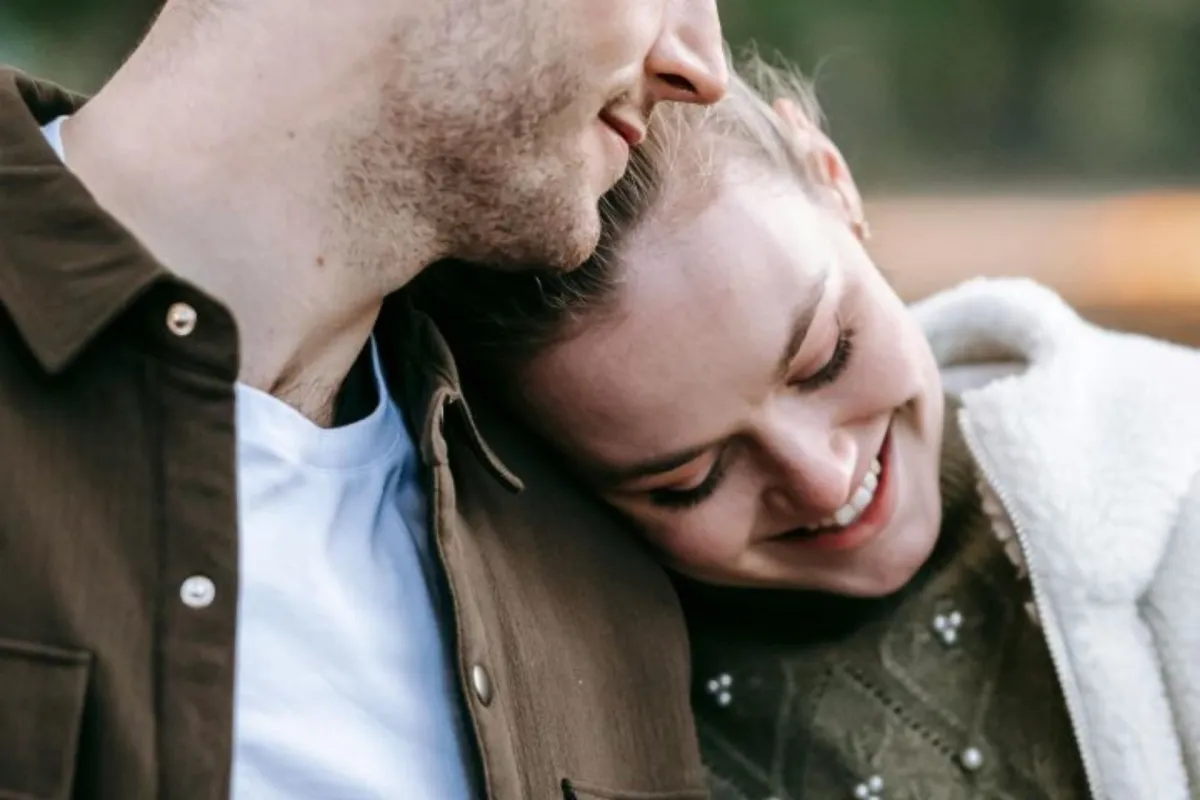 فتاة تضع رأسها على كتف خطيبها برومانسية وهو ينظر لها بمحبة