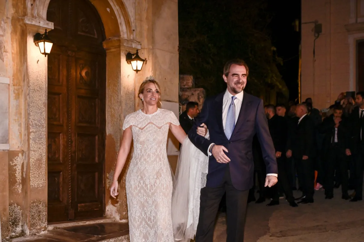 الأمير نيكولاوس وزوجته كريسي فاردينوجياني يغادران كنيسة القديس نيكولاس راجافاس المقدسة خلال حفل زفافهما في أثينا (Prince Nikolaos and his wife Chrysi Vardinogianni leave the Holy Church of Saint Nicholas Ragavas during their wedding in Athens). مصدر الصورة: Spyros BAKALIS / AFP