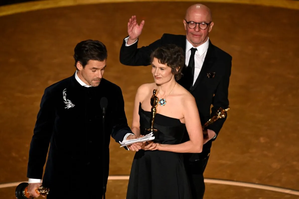 كليمنت دوكول وكاميل وجاك أوديار خلال حفل توزيع جوائز الأوسكار السنوي السابع والتسعين في مسرح دولبي في هوليوود، كاليفورنيا (Clement Ducol, Camille and Jacques Audiard during the 97th Annual Academy Awards at the Dolby Theatre in Hollywood, California). مصدر الصورة: Patrick T. Fallon / AFP