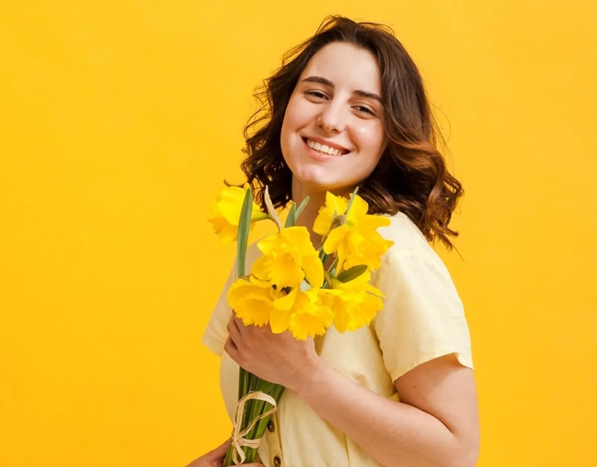 سيدة تحمل زهرة الربيع المسائية Image By Freepik