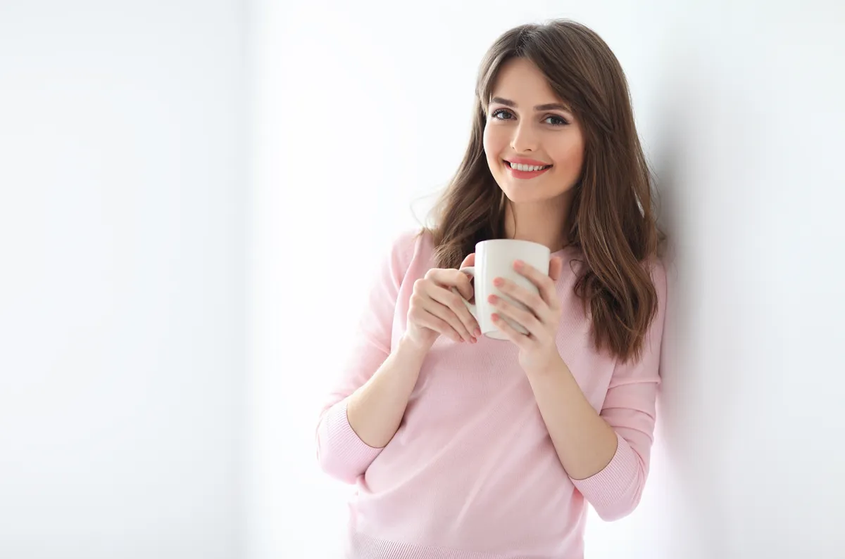 امرأة تشرب شاي الأعشاب للتخلص من النفخة