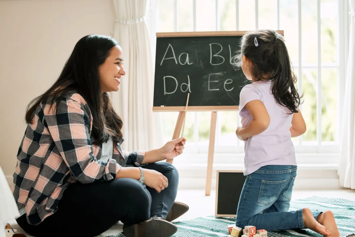 صورة أم تعلم طفلتها اللغة