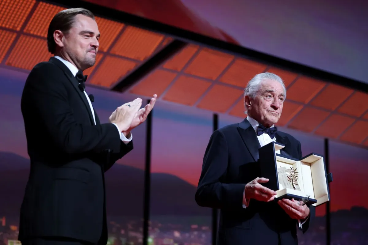 روبرت دي نيرو يتسلم جائزة السعفة الذهبية الفخرية من ليوناردو دي كابريو في قصر المهرجانات بمدينة كان الفرنسية (Robert De Niro accepts the honorary Palme d'Or from Leonardo DiCaprio at the Palais de Festival in Cannes, France). مصدر الصورة: Pascal Le Segretain/Getty Images