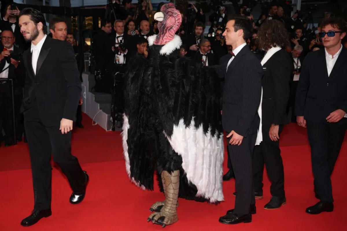 هوغو ديفيد يلتقط صورة مع ضيف يرتدي زي ديك رومي في الدورة 78 من مهرجان كان السينمائي في كان، جنوب فرنسا (Hugo David poses with a guest dressed as turkey at the 78th edition of the Cannes Film Festival in Cannes, southern France). مصدر الصورة: Valery HACHE / AFP