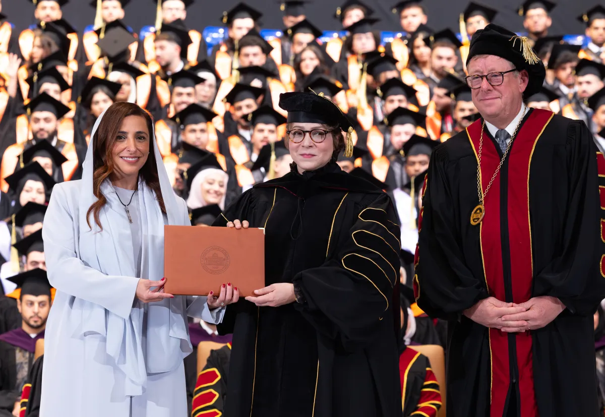 من اليمين البروفيسور تود لارسون عميد الجامعة والبروفيسورة مناهل ثابت تتسلم الدكتوراه الفخرية من الشيخة بدور القاسمي