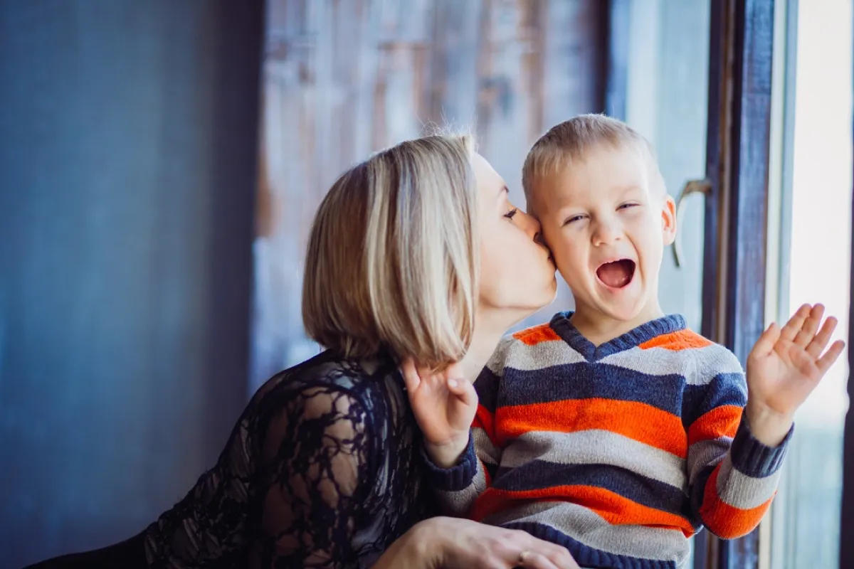 صورة لطفل مصاب بالمهق يلهو مع أمه