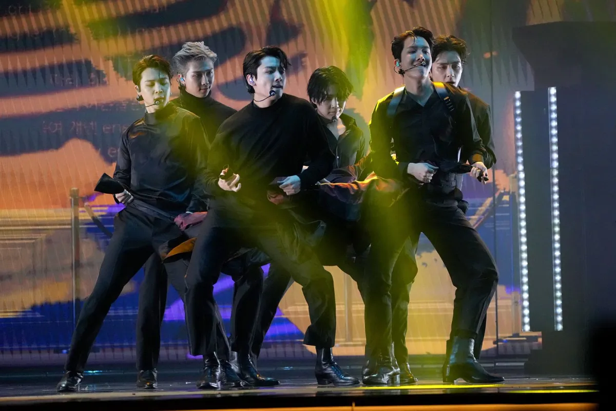 جيمين، آر إم، جونغكوك، شوغا، جايهوب، وڤي من فرقة بي تي إس في قاعة إم جي إم غراند غاردن أرينا في لاس فيغاس، نيفادا (Jimin, RM, Jungkook, Suga, J-Hope, and V of BTS at MGM Grand Garden Arena in Las Vegas, Nevada). مصدر الصورة: Kevin Mazur/Getty Images for The Recording Academy