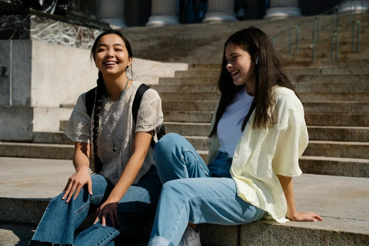 صديقتان تمرحان وتقضيان وقتاً ممتعاً معاً وتبتسمان بسعادة 