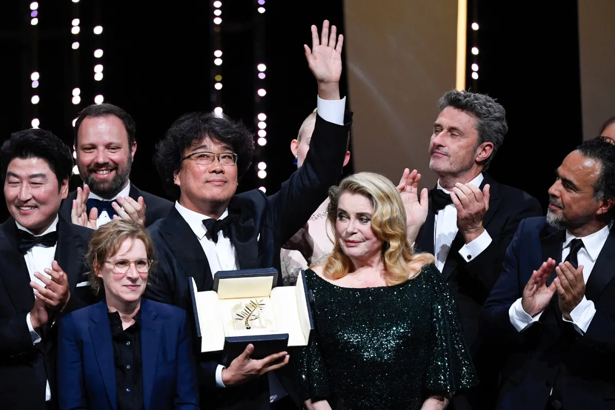 صورة جماعية لصناع فيلم Parasite بعد حصوله على جائزة السعفة الذهبية بمهرجان كان – مصدر الصورة CHRISTOPHE SIMON / AFP