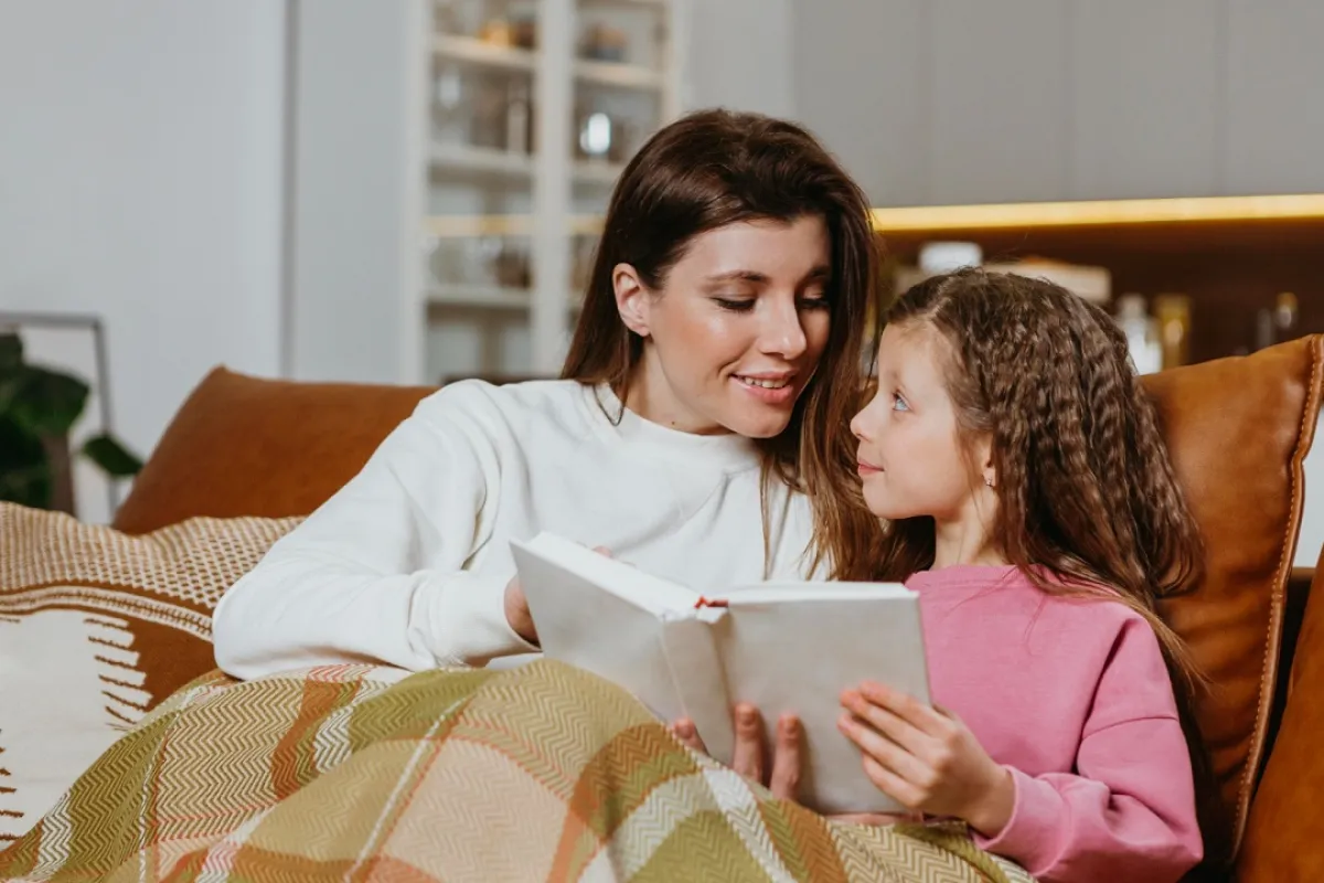 صورة لأم تقرأ لطفلتها