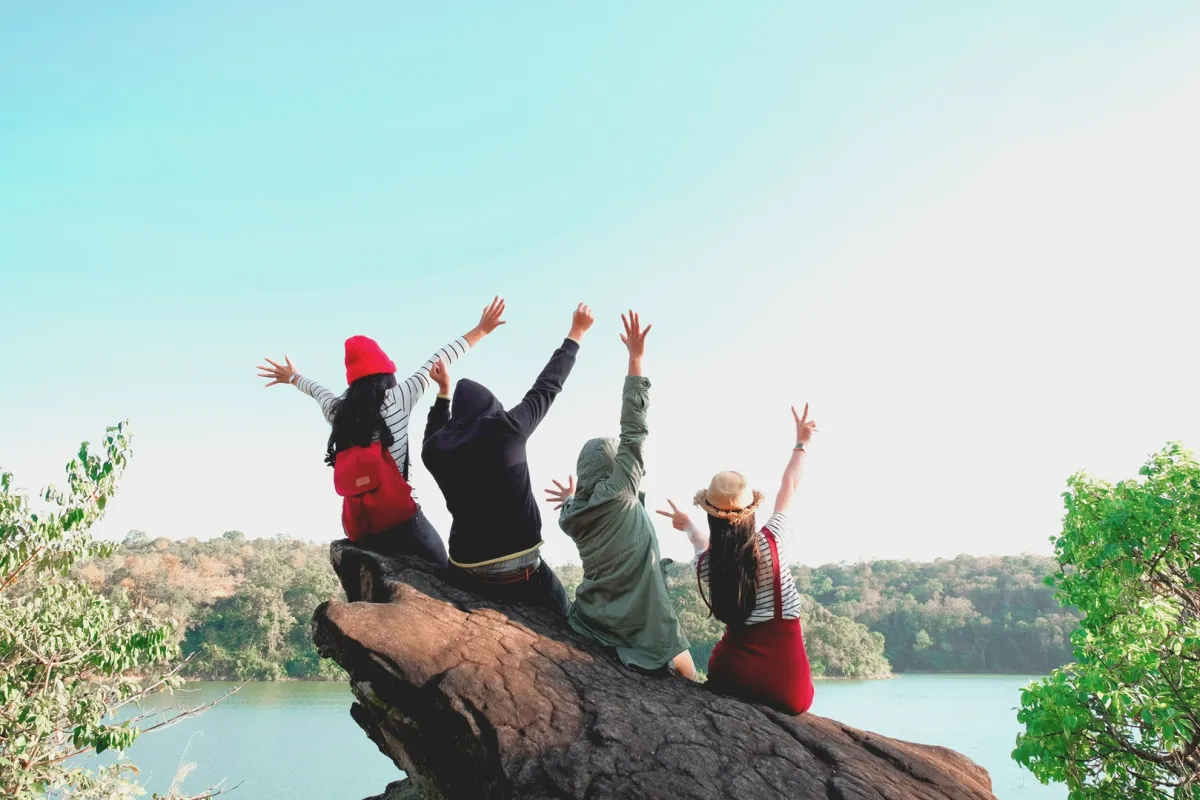 عدد من الأصدقاء يستمتعون بالطبيعة ويحتضنون بعضهم البعض