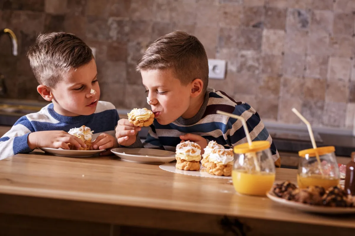 صورة طفلين يأكلان الحلوى بشغف