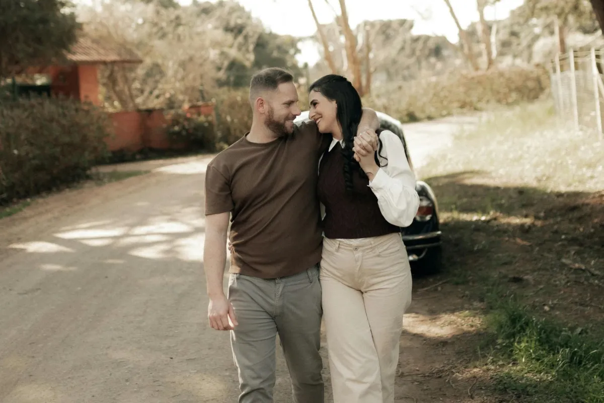 زوجان يبدو عليهما التفاهم ويتنزهان بسعادة حيث الزوج يضع يده على كتف زوجته وهي تنظر له بمحبة