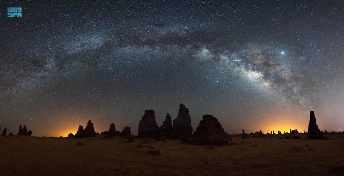 السماء المرصعة بالنجوم فوق تشكيلات صخرية في العلا