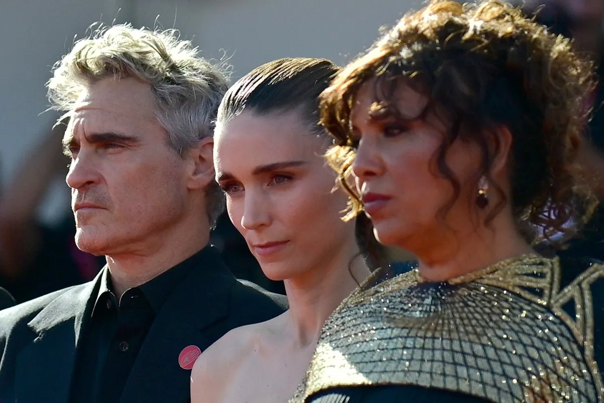 الممثل الأمريكي خواكين فينيكس والممثلة الأمريكية روني مارا والمخرجة التونسية كوثر بن هنية يحضرون السجادة الحمراء لفيلم "صوت هند رجب" المعروض في المسابقة الرسمية في مهرجان فينسيا السينمائي الدولي الـ 82 (US actor Joaquin Phoenix, US actress Rooney Mara and Tunisian director Kaouther Ben Hania ttend the red carpet for the movie "The Voice of Hind Rajab" presented in competition at the 82nd International Venice Film Festival)- مصدر الصورة:  Tiziana FABI / AFP