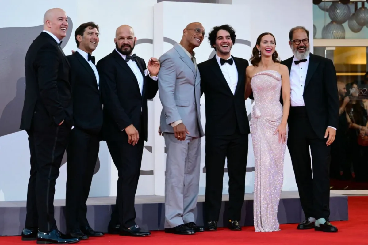 حيرام جارسيا، ديفيد كوبلان، مارك كير، دواين جونسون، بيني سافدي، إميلي بلانت وأندريا روميو (Hiram Garcia, David Koplan, Mark Kerr, Dwayne Johnson, Benny Safdie, Emily Blunt and Andrea Romeo)، من مهرجان فينيسيا السينمائي 2025. مصدر الصورة: Tiziana FABI / AFP