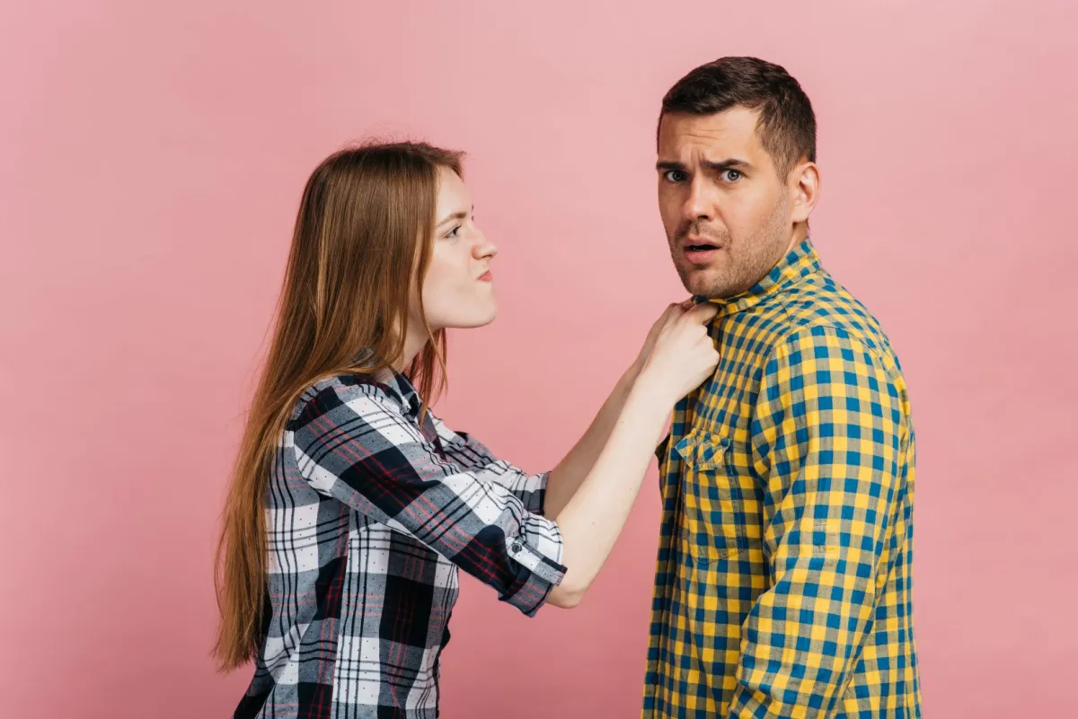 سيدة عصبية تمسك بثياب زوجها من الغضب   