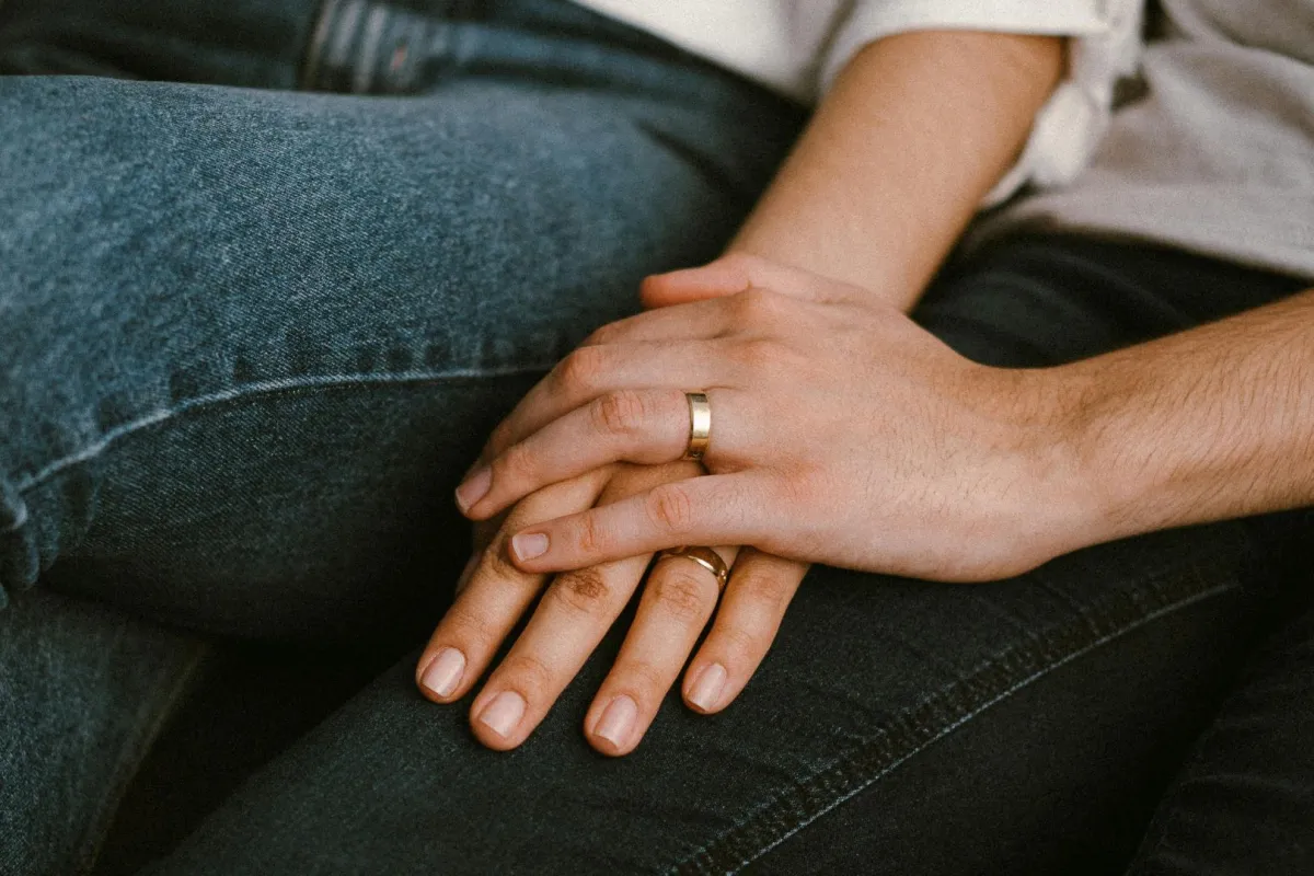 زوج يضع يده على يد زوجته علامة المحبة والدعم