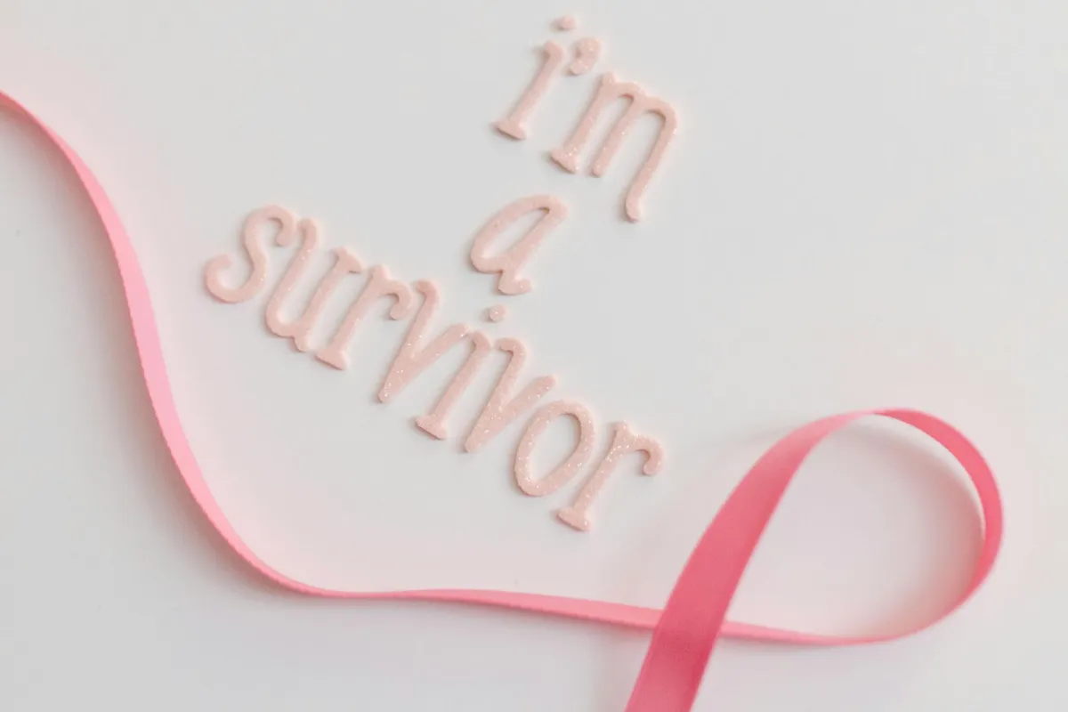  الشريط الوردي علامة سرطان الثدي ومعه عبارة أنا ناجية من سرطان الثدي