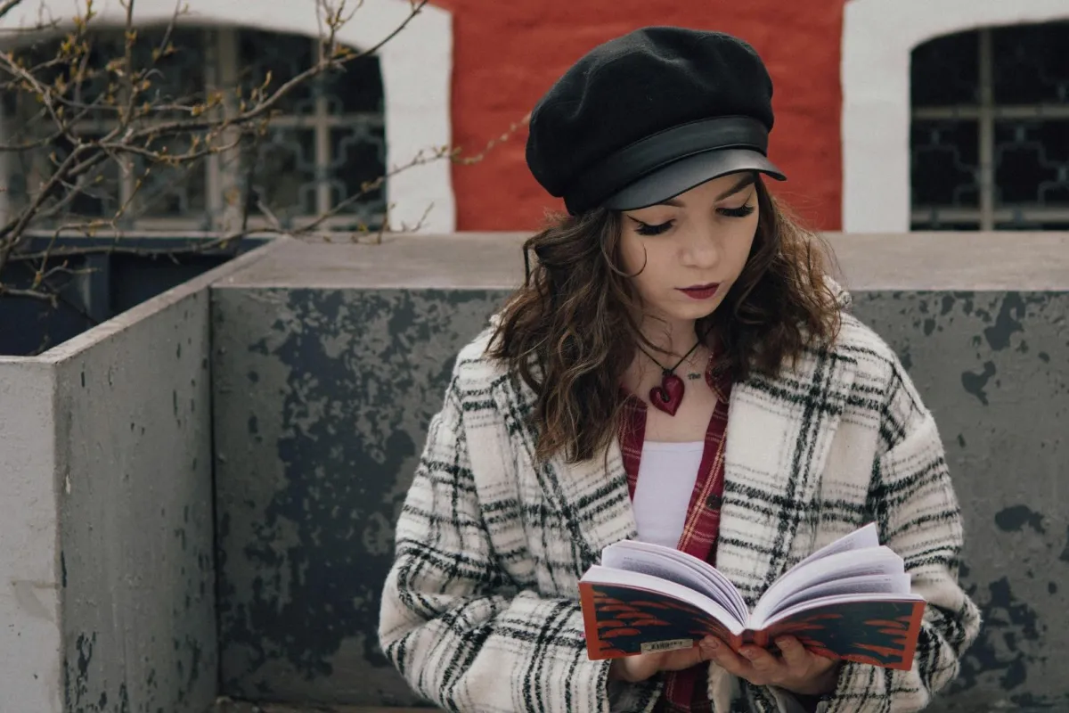 فتاة تقرأ كتاب في بلكونة المنزل