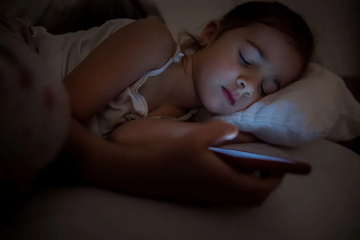 فتاة تطالع الموبايل قبل النوم
