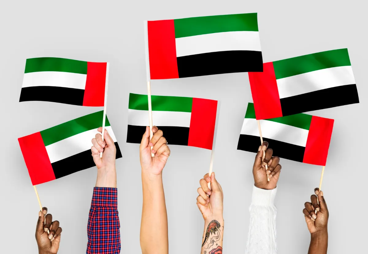 اطفال يرفعون العلم الاماراتي- مصدر الصورة freepik