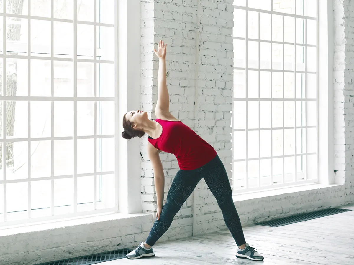 سيدة تهيئ جسمها  قبل التمارين Image by shurkin_son on Freepik