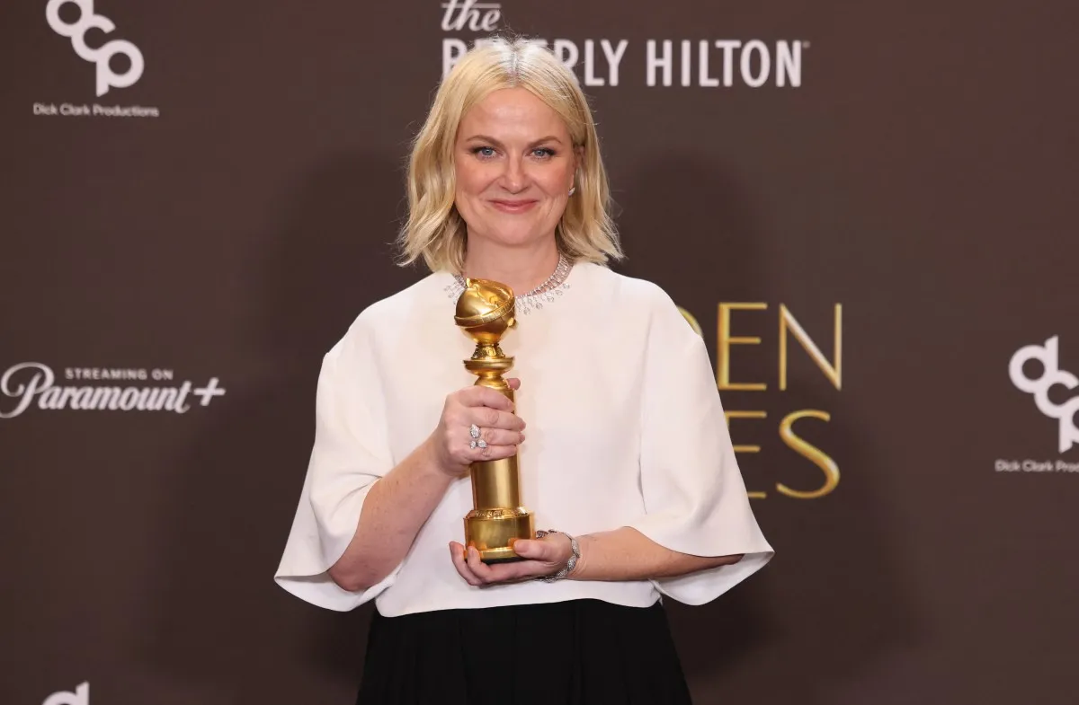 آيمي بولر تحمل جائزتها في حفل توزيع جوائز غولدن غلوب 2026 (Amy Poehler holding her award at the 2026 Golden Globe Awards)- مصدر الصورة: Etienne Laurent / AFP 
